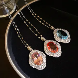 Primer plano de tres collares con colgante ovalado de circón en rosa, rojo y azul.