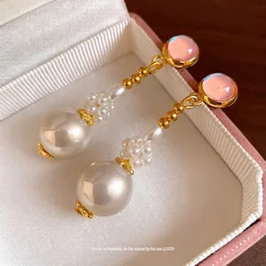 Eleganti orecchini pendenti in resina rosa e perle con catena di perline dorate