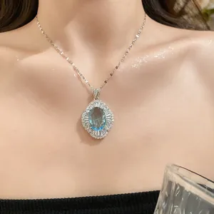 Vista detallada de un collar con colgante ovalado de piedra azul en la clavícula.