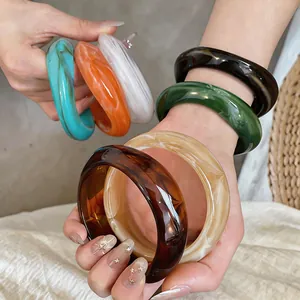 Gros plan de bracelets géométriques irréguliers en acrylique avec motifs marbrés chics