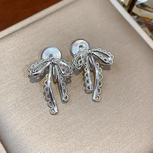 Exquisite close-up detail of silver lace bow clip-on earrings for non-pierced ears