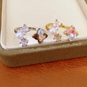Elegant open ring with zircon flower and pearl accents in gold and silver finish