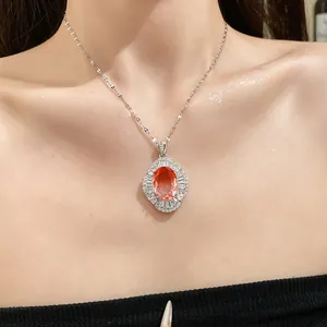 Detalle de un elegante collar con un gran colgante de circón naranja en el cuello.