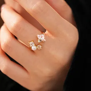 Elegant gold plated open ring featuring a zircon flower and pearl worn on a finger