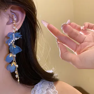 Dettaglio dell'orecchino a polsino con fiori in chiffon blu e nappe di perle eleganti