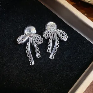 Detailed macro shot of elegant silver lace bow clip-on earrings for unpierced ears