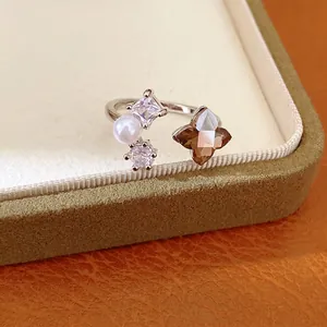 Silver open ring featuring zircon flower, pearl and sparkling gemstones