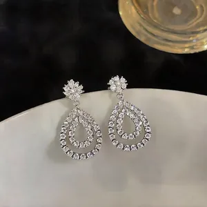 Macro detailed view of elegant hollow water-drop earrings with sparkling pavé zircon stones