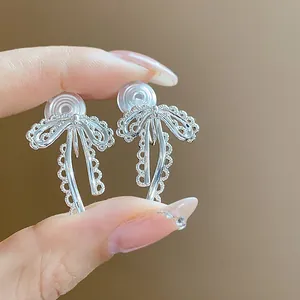 Close-up detail of silver lace bow-knot clip-on earrings for non-pierced ears