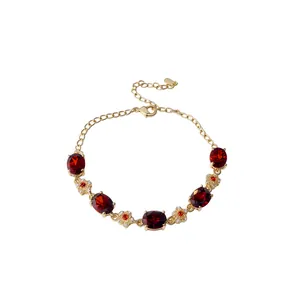 18k gold plated bracelet featuring oval red zircons and dainty flower charms