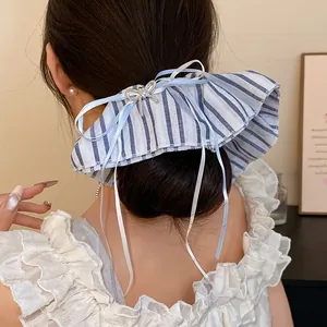 Vue détaillée d'un chouchou en tissu à rayures bleues et blanches avec un nœud élégant
