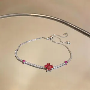 Detail view of an elegant silver zircon flower bracelet with red heart-shaped petals.