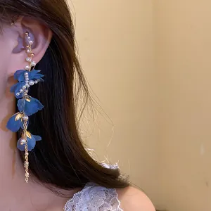 Dettaglio di orecchino ear cuff con fiori in chiffon blu e perle e catena dorata