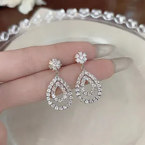 Detailed view of teardrop hollow earrings with pavé-set shimmering cubic zirconia stones