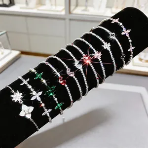 Detailed view of sparkling zircon flower and butterfly charm bracelets on velvet