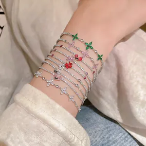 Close-up of multiple colorful zircon flower bracelets worn on a wrist in Korean ins style.