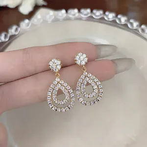 Macro detail view of elegant vintage hollow teardrop earrings with sparkling cubic zirconia