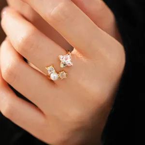 Detailed view of an elegant gold flower open ring with zircon stones and a pearl
