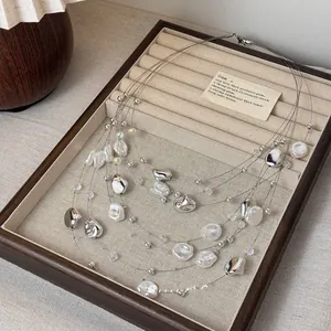 Close-up detail of multi-strand vintage necklace with irregular pearls and silver beads