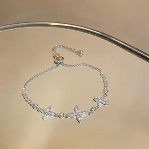 Close-up of silver-toned adjustable bracelet with sparkling zircon flower motifs