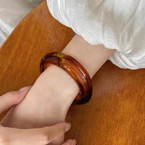 Gros plan d'un bracelet en acrylique marbré ambre au design géométrique unique