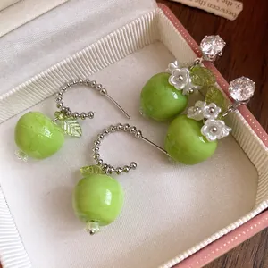 Nahaufnahme grüner Harz-Apfelohrringe mit Zirkonia und eleganten Blumendetails