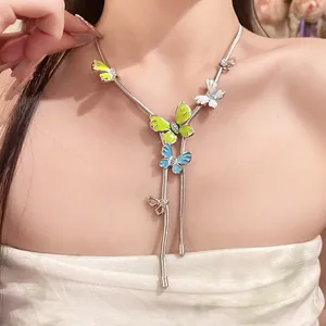 Detail view of a silver snake chain necklace with colorful enamel butterfly pendants.