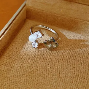 Detailed view of an open ring with zircon flower, white pearl and clear crystal accents