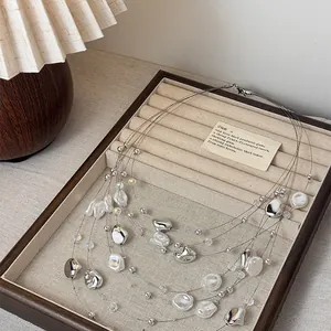 Close-up of elegant multi-layered vintage pearl necklace with irregular silver beads