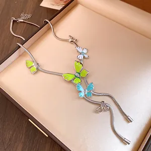 Close-up detail of colorful enamel butterfly pendants with rhinestones on a snake chain