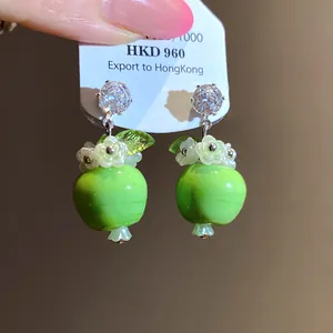 Detailaufnahme von grünen Apfel-Ohrringen aus Harz mit Zirkon-Stecker und Silberstift