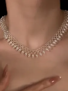 Close-up detail of an elegant vintage pearl lace choker necklace with beaded design