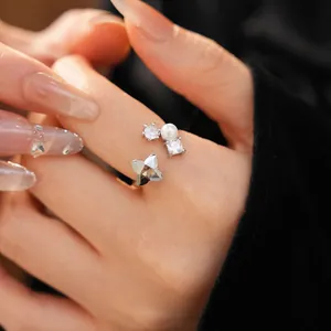 Detail of silver-tone open ring with zircon flower and white pearl accents