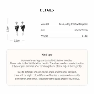 Detail view of heart-shaped resin earrings with freshwater pearls and 925 silver needles.