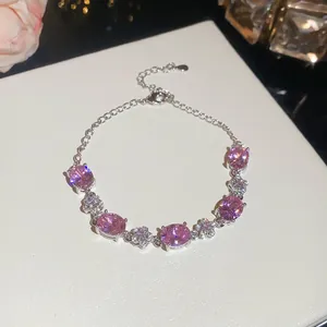 Elegant close-up of a silver bracelet featuring pink oval zircons and floral motif designs