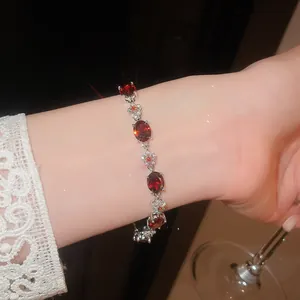 Elegant bracelet with red oval zircons and floral silver links on wrist