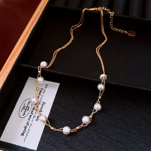 Detail view of 18k gold plated double chain necklace with elegant white pearls