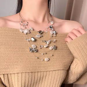 Detail view of a vintage multi-layer beaded pearl necklace on an elegant model