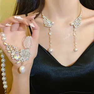 Detailed view of an elegant rhinestone and pearl choker necklace worn by a model in a black dress.