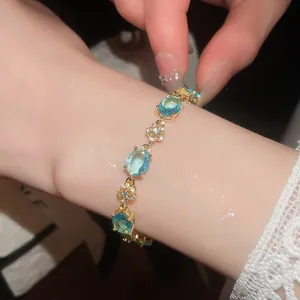 Elegant 18k gold plated bracelet with light blue oval crystals and flower charms