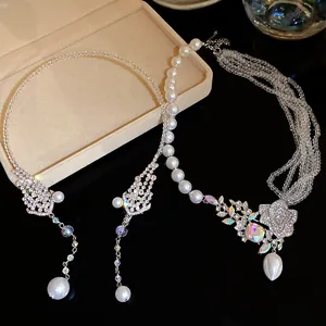 Close-up of elegant beaded pearl necklaces with sparkling crystal floral pendant detail.