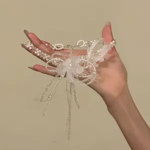 Detail of elegant white feather flower necklace with pearls and crystal beads
