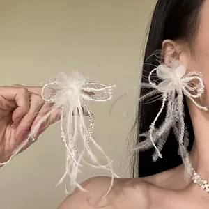 Detailed view of a bridal white feather flower jewelry set with pearls for an elegant look