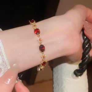 Close-up view of elegant 18k gold plated bracelet featuring red oval zircons and flowers