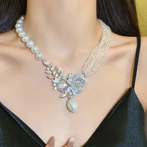 Detailed view of an asymmetrical pearl and bead necklace with a sparkling crystal flower pendant