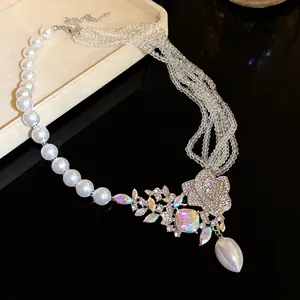 Detailed close-up view of an elegant pearl and rhinestone flower pendant necklace in silver