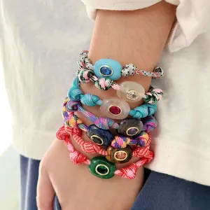 Detail shot of bohemian colorful woven cord bracelets with natural stone evil eye charms