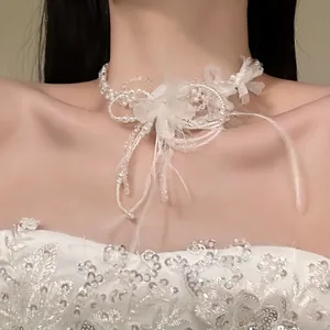 Close-up of elegant white feather choker necklace with pearl and flower details