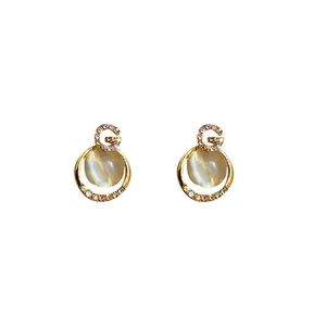 Luxury gold-plated letter G stud earrings featuring cat-eye stones and sparkling crystals