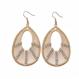 Eleganti orecchini a goccia dorati con strass scintillanti per una donna sofisticata.